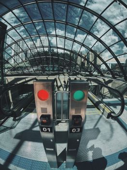 Urban transit turnstiles under a glass dome in a city setting, showcasing architecture.