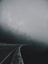 蜿蜒的道路消失在浓雾中，营造出一种诡异而神秘的氛围