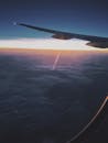 日落时分，飞机机翼掠过云层，捕捉到宁静的旅行瞬间