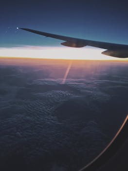 日落时分，飞机机翼掠过云层，捕捉到宁静的旅行瞬间