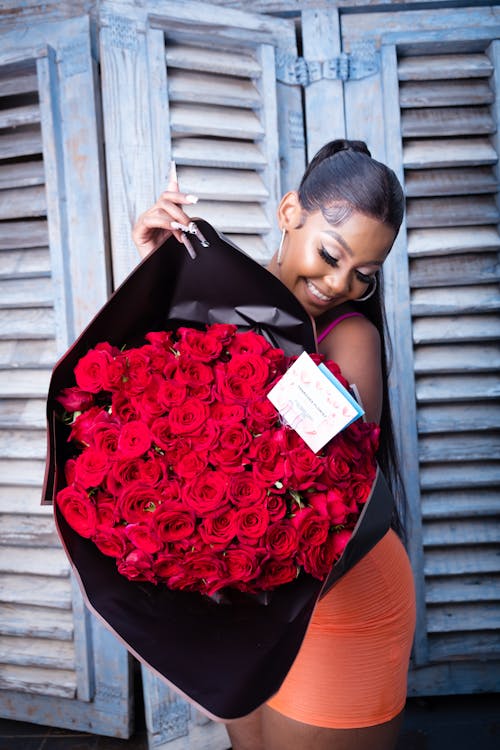 Young Woman Holding a Big Bouquet of Red Roses
