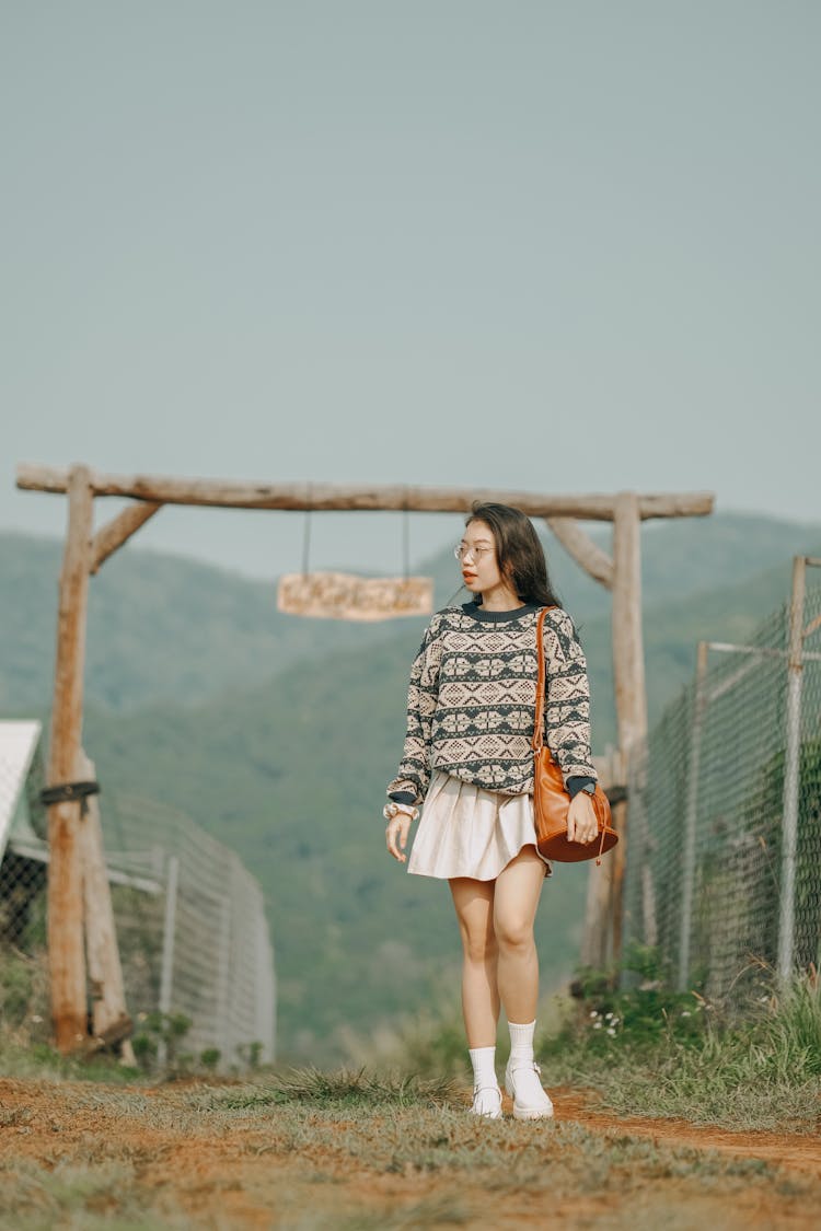 Woman In Skirt Standing Near Gate