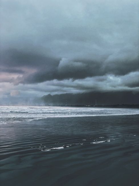 A breathtaking view of a moody ocean and dramatic clouds at dusk, offering a serene yet intense atmosphere.