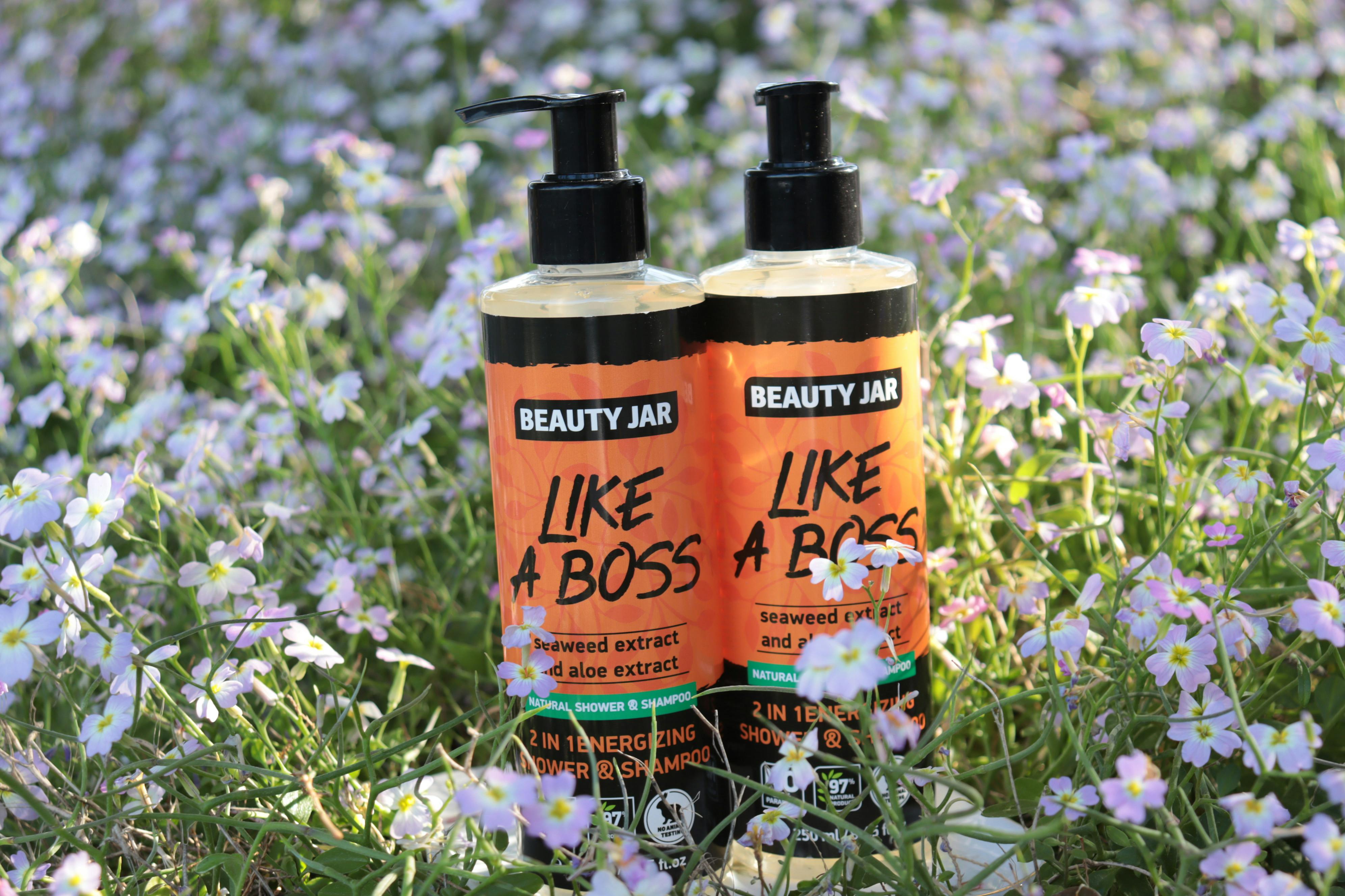 Beauty Jar 'Like a Boss' shampoo bottles surrounded by vibrant wildflowers, capturing freshness and nature's energy.