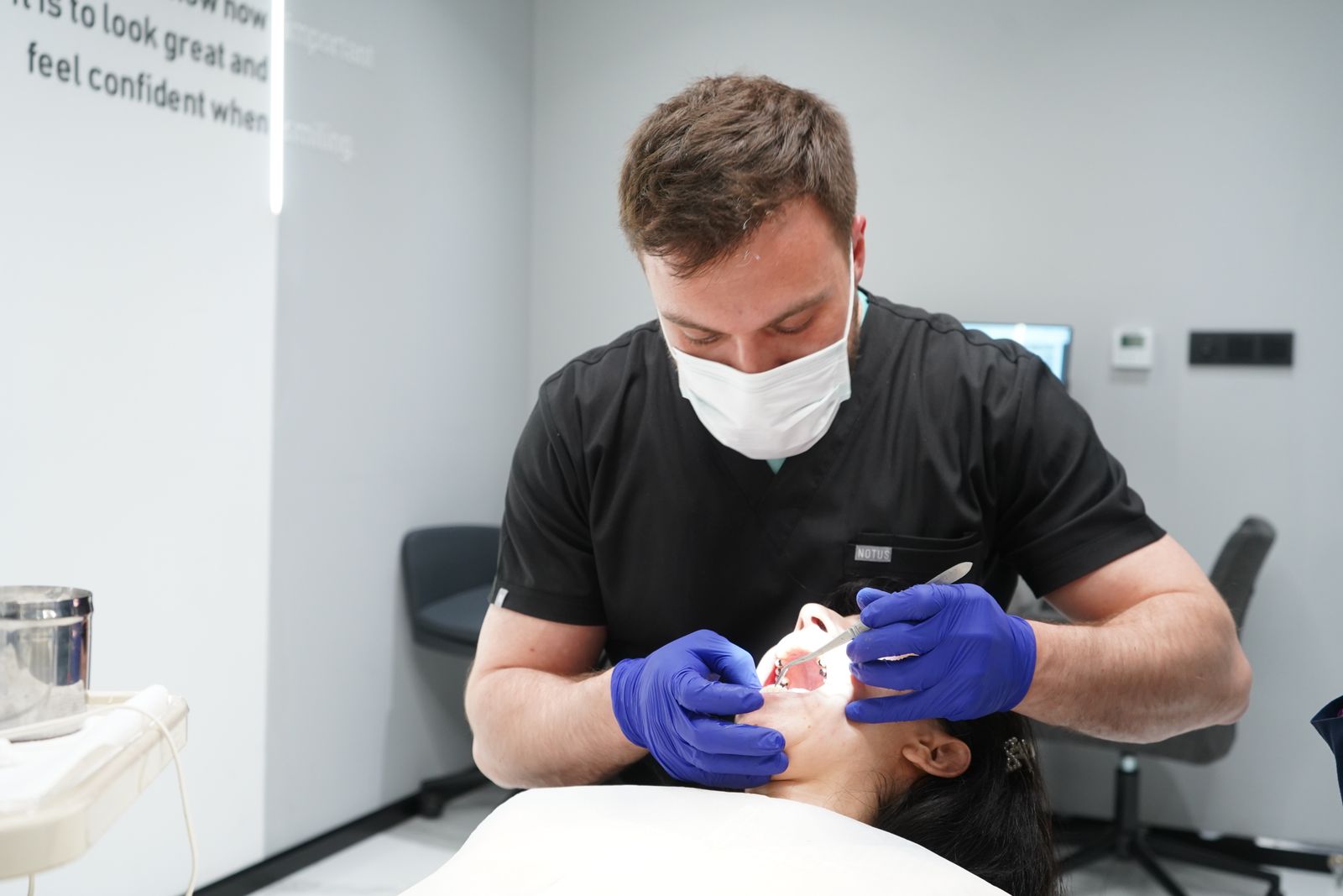 Dentista che esegue un controllo estetico su una paziente in clinica moderna