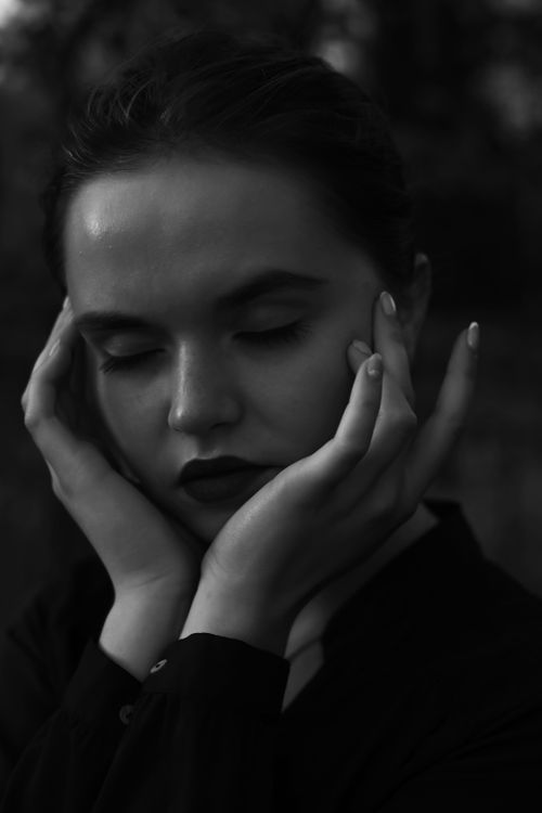 Free Elegant black and white portrait of a woman in contemplation, showcasing dramatic lighting and posing. Stock Photo