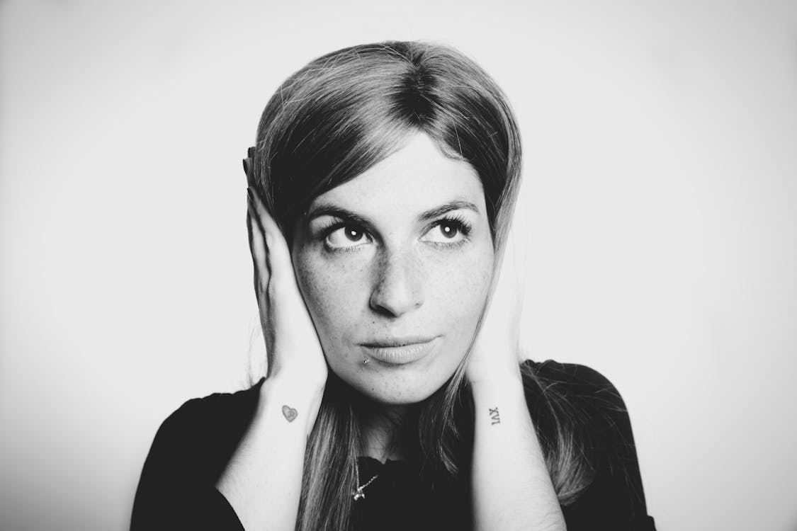 Close-up Photo of Woman Covering Her Ears