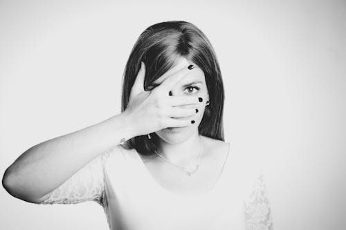 Grayscale Photo of Woman Covering Face