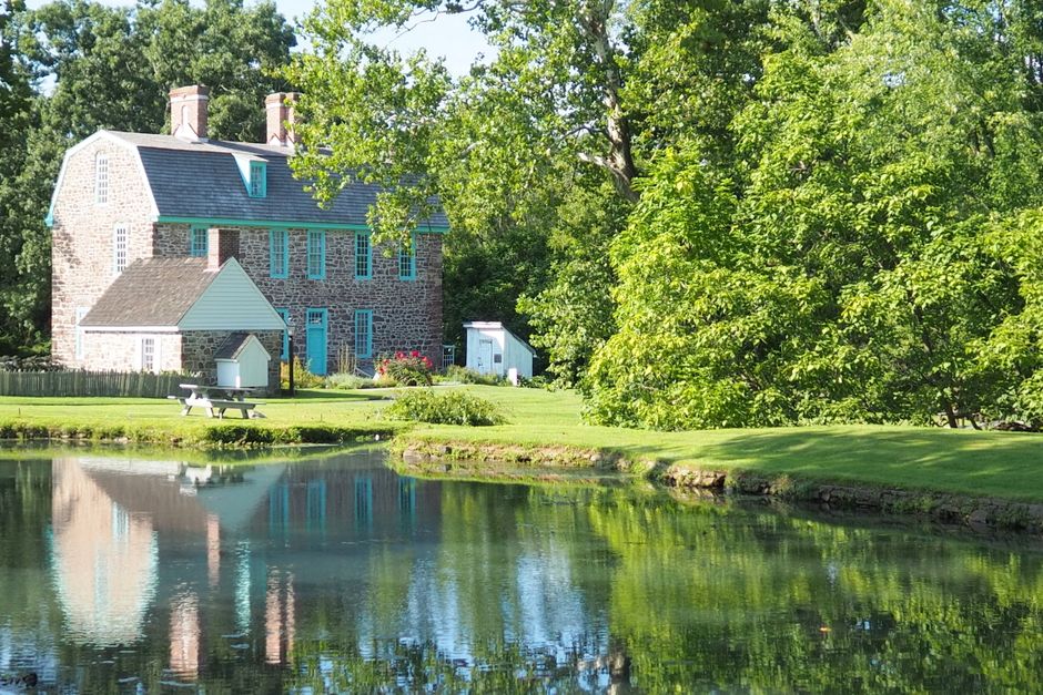 Charming Keith House reflecting in a tranquil pond with lush greenery in Horsham, Pennsylvania.