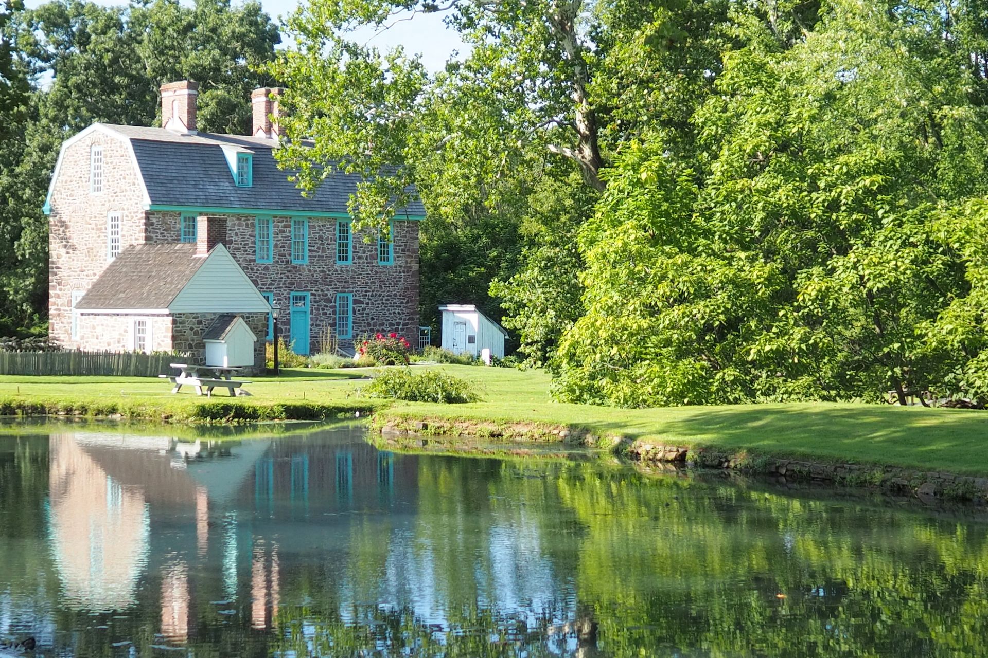 Charming Keith House reflecting in a tranquil pond with lush greenery in Horsham, Pennsylvania.