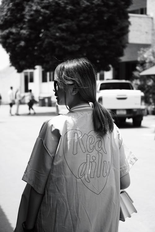 Back View of a Young Woman Walking in City 