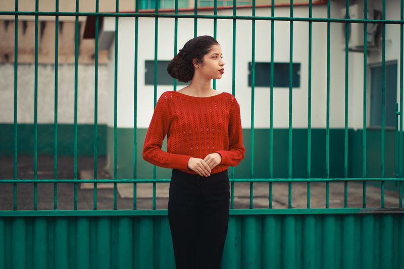 woman in red turtleneck sweater and black midi skirt