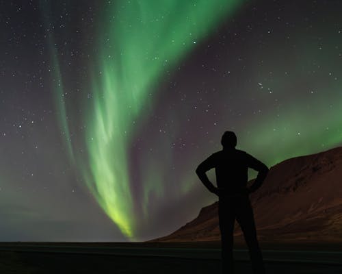 Aurora Borealis over Man Silhouette at Night