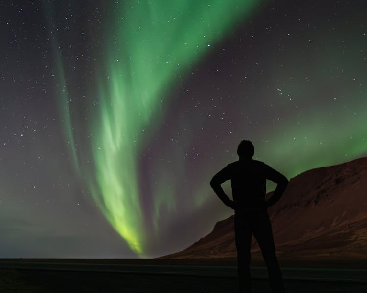 Aurora Borealis Over Man Silhouette At Night