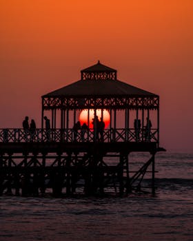 People silhouetted against a sunset on a pier in Huanchaco, Perú.