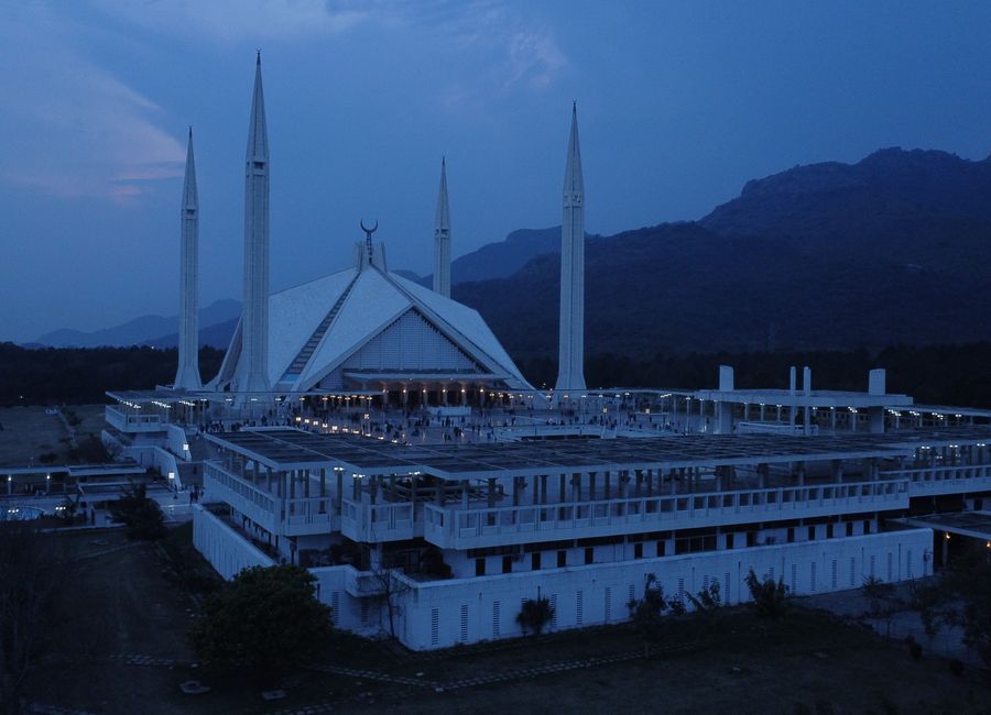 Aerial view of Faisal Mosque in Islamabad during evening twilight, showcasing its iconic minarets.