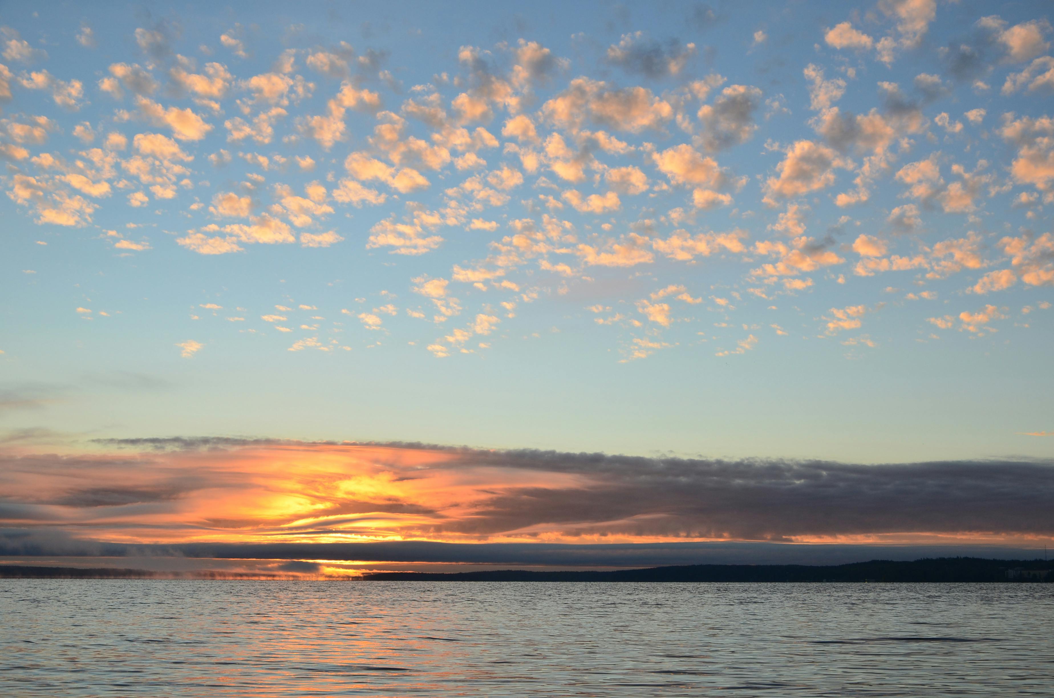 Breathtaking sunset over the calm sea in Tampere, Finland with vibrant clouds. - Tampere