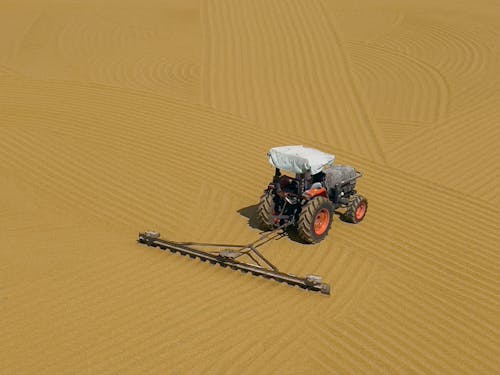 Tractor Plowing Sand Field