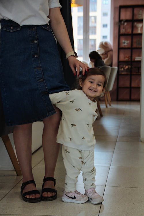 Portrait of a Smiling Little Girl in Pajamas Playing with Her Mother