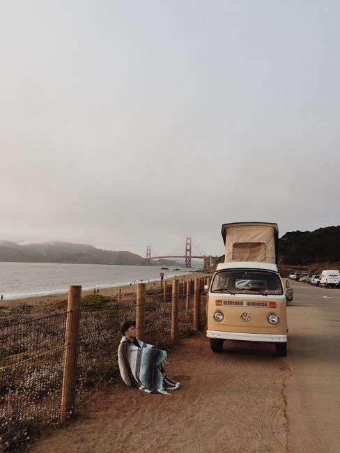 A scenic view of a classic VW van by the Golden Gate Bridge, perfect for travel and adventure themes.