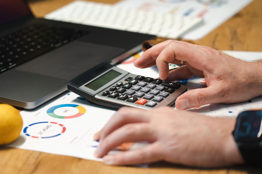Person prüft Finanzunterlagen am Laptop