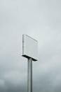 An empty billboard stands tall against a cloudy, overcast sky, perfect for mockup design.