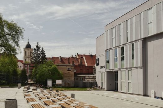 Modern and historic buildings with outdoor benches in Zielona Góra, Poland.