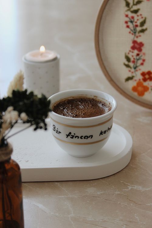 Free Warm coffee setup with candle, embroidery, and flower decor for a comforting vibe. Stock Photo