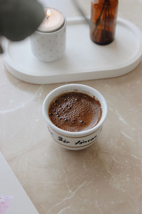Free A calming indoor scene of coffee with a lit candle, perfect for a cozy atmosphere. Stock Photo