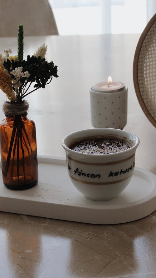 Cup of Coffee and a Candle on the Table 