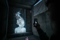 一个人在弱光条件下用智能手机拍摄城市艺术品