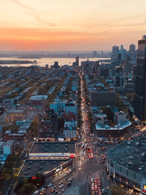 Free A breathtaking aerial view of New York City streets and skyline during sunset. Stock Photo