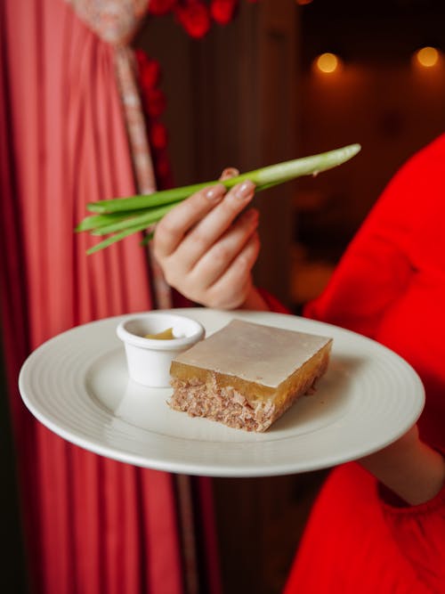 Chives in Woman Hand over Plate with Cake