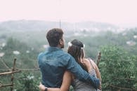 一对夫妇在风景优美的多雨乡村里撑着伞拥抱