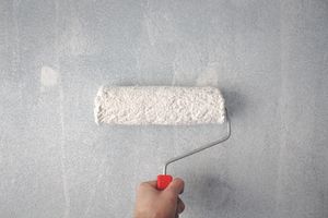 Close-up of a paint roller loaded with white paint