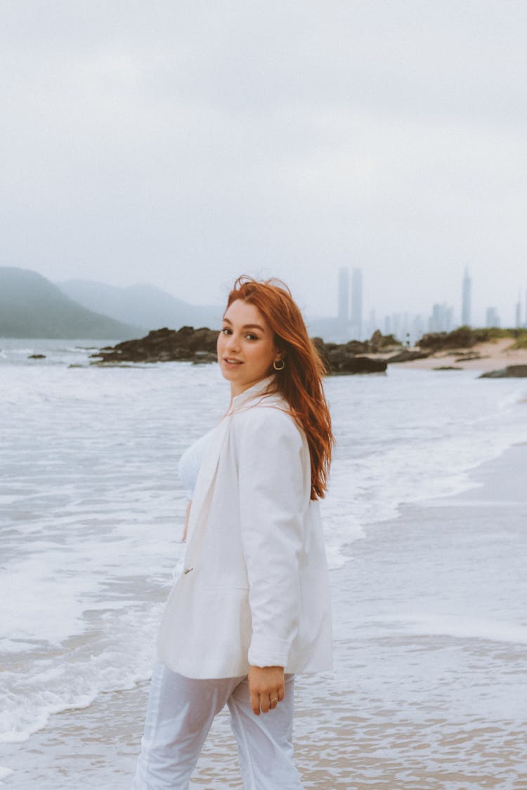 Redhead Woman In Suit Walking On Beach