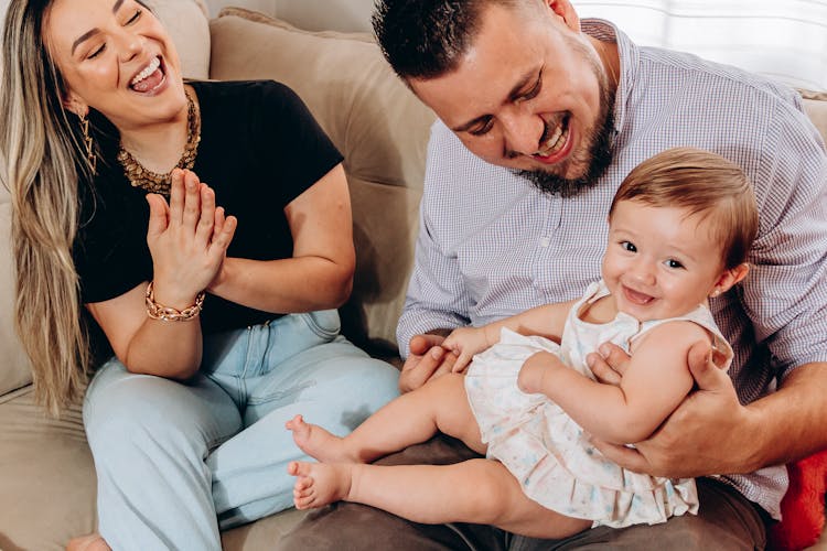 Parents Having Fun And Laughing With Their Baby Girl 