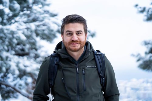 Free Portrait of a man wearing a jacket outdoors with a snowy background. Stock Photo