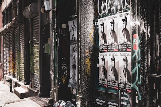 Gritty urban street shot in New York City featuring posters and graffiti in a deserted alleyway.