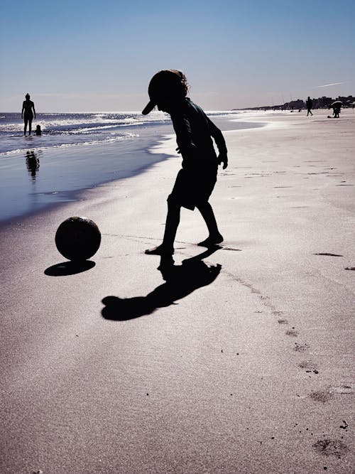 Child Playing with Ball on Beach