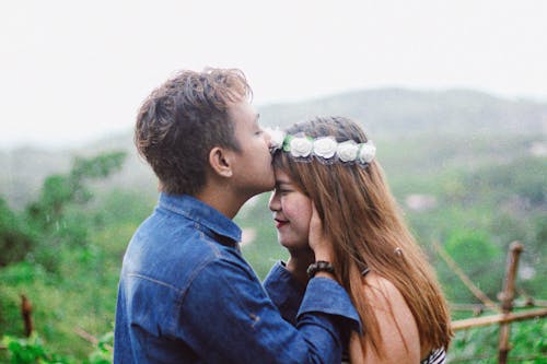 Man Wearing Blue Denim Jacket While Kissing Woman's Forehead