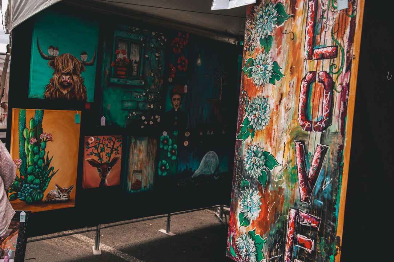 colorful display of diverse artworks at an outdoor art fair highlighti