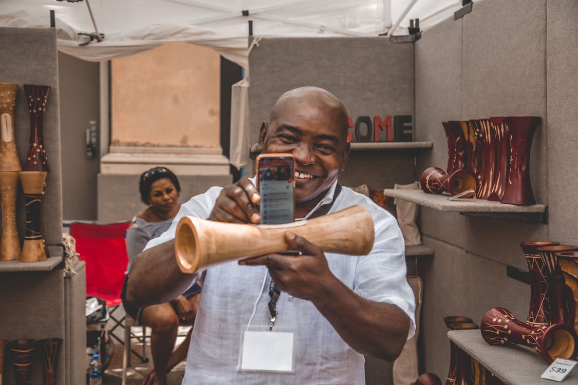 Free Man Taking Photo of Brown Decorative Speaker Stock Photo