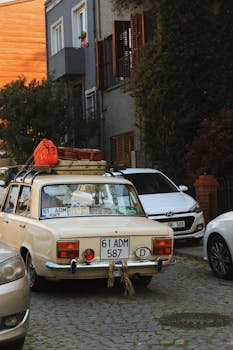 Retro car with luggage parked in a cozy alley in İstanbul, Türkiye.