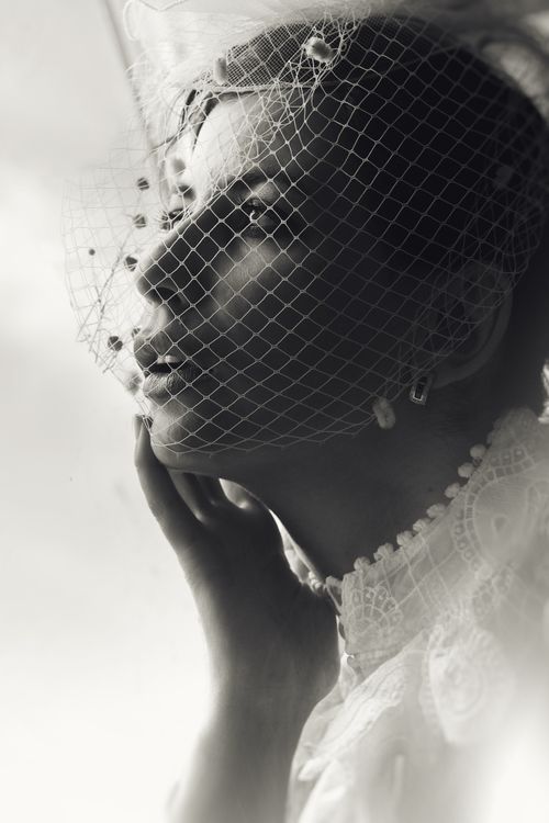 Free A captivating black and white portrait of a bride with a delicate veil, capturing classic beauty. Stock Photo