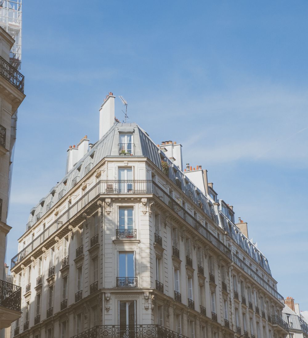 Façade d’un immeuble parisien ancien sous un ciel bleu