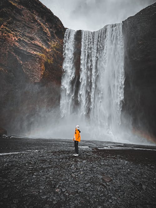 Free A Person Standing in front of the Skogafoss Waterfall in Iceland  Stock Photo