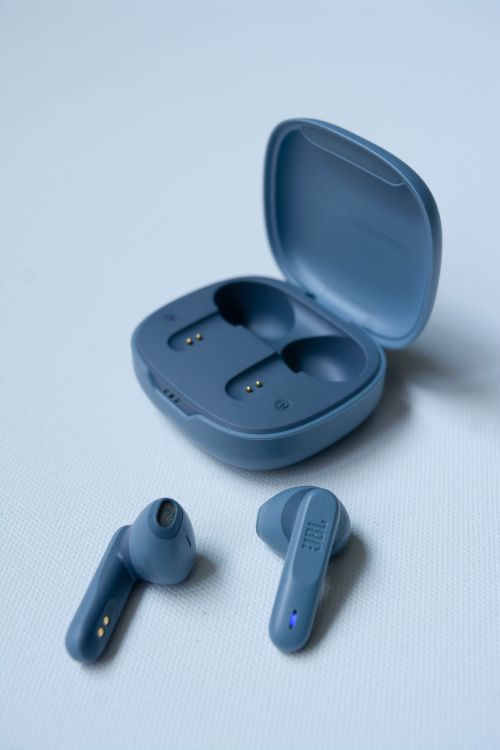 Close-up of wireless earphones and their open charging case.