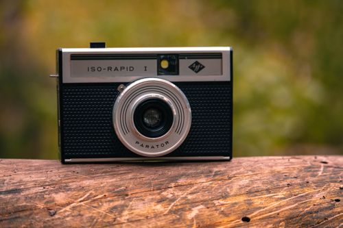 Free Close-up of a classic ISO-Rapid I analog camera on wood with blurred nature background. Stock Photo