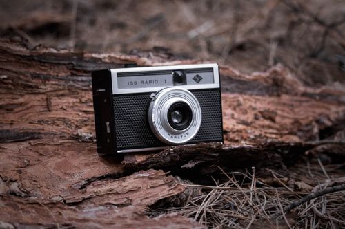 Free Close-up of a vintage camera on a rustic wooden surface, capturing nostalgia. Stock Photo